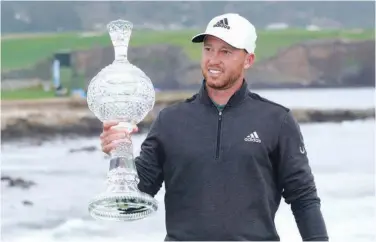  ?? Associated Press ?? ↑
Daniel Berger poses with the trophy after winning the Pebble Beach Pro-am Golf Links tournament on Sunday.