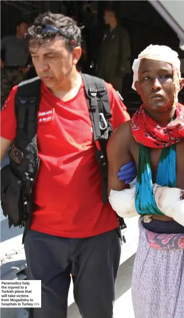  ?? EPA ?? Paramedics help the injured to a Turkish plane that will take victims from Mogadishu to hospitals in Turkey