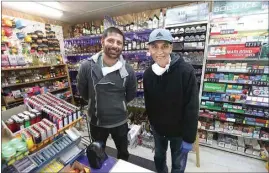  ??  ?? R.J. Joshan, left, manager at EZ Stop Liquor on Roberts Lane, said some customers are taking the pandemic seriously but not all are. His father, Sucha Joshan, is owner of the shop, which has been in business since 1998.