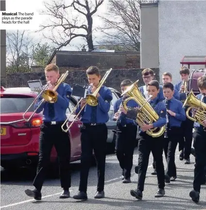  ??  ?? Musical The band plays as the parade heads for the hall