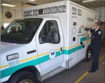  ?? PETE BANNAN - DIGITAL FIRST MEDIA ?? Crozer paramedic David White plugs in Medic 82 which will carry the body of Chief Robert Reeder.