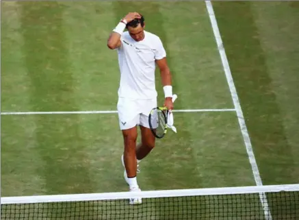  ?? CLIVE BRUNSKILL, GETTY IMAGES ?? A dejected Rafael Nadal walks off the court after losing to Gilles Muller at Wimbledon on Monday. Nadal lost 6-3, 6-4, 3-6, 4-6, 15-13.