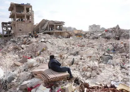  ?? RAMI AL SAYED/AFP VIA GETTY IMAGES ?? A resident of Jindayris, in the rebel-held part of Aleppo province in Syria, rests on a salvaged mattress Friday as search and rescue operations continue days after a deadly earthquake.