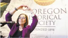  ?? Don Ryan / Associated Press ?? Secretary of State Kate Brown, a bisexual next in line to be governor, signs a hand heart during a celebratio­n.