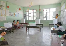  ?? — Reuters ?? Election volunteers wait for voters at a polling station during by-elections in Yangon, Myanmar on Saturday.