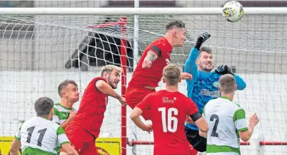  ??  ?? Buckie goalkeeper Kevin Main punches the ball away as his team defend a Brora corner-kick