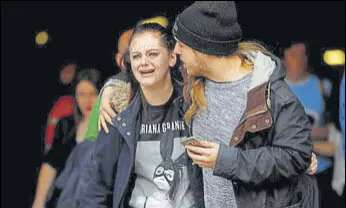  ?? REUTERS ?? A man tries to comfort a panicstric­ken Ariana Grande fan after the suicide bombing at the American pop star’s concert in Manchester on Tuesday.