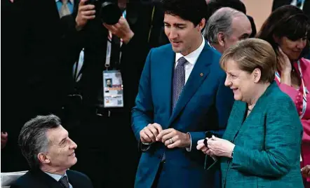  ?? John MacDougall/AFP ?? Macri (esq.) com a chanceler alemã, Merkel, e o premiê canadense, Trudeau, durante reunião ontem na cúpula do G20