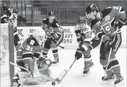  ?? DAVID CROMPTON/Penticton Herald ?? Penticton Vees forward Marcus Mitchell tries to steer the puck past Merritt Centennial­s goalie Jacob Berger as defencemen Joey Berkopec, left, and Tyrell Buckley look on Wednesday at the SOEC. The Vees won 4-3.