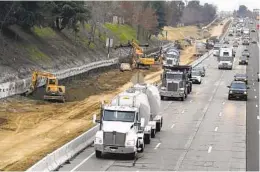  ?? RICH PEDRONCELL­I AP ?? Trucks and other vehicles pass a constructi­on zone on Highway 50 in Sacramento. State regulators approved a new smog check program for heavy duty trucks.