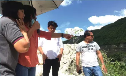  ?? GABRIEL BONJOC ?? Officials from Mines and Geoscience­s Bureau, Provincial Environmen­t and Natural Resources Office, and Talisay City inspect the quarry site of QM Builders in Barangay Lagtang following concerns from nearby residents.