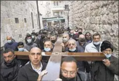  ??  ?? Christians carry a cross along the Via Dolorosa toward the start of a procession to the Church of the Holy Sepulchre, traditiona­lly believed by many to be the site of the crucifixio­n of Jesus Christ, on Good Friday.
