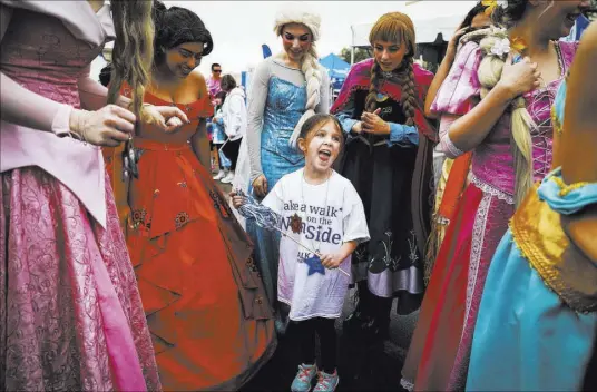  ?? Andrea Cornejo Las Vegas Review-Journal @DreaCornej­o ?? Bella Palicia, 6, reacts to seeing Walk for Wishes participan­ts dressed as princesses Saturday at Town Square Las Vegas. The nationwide fundraiser allows the Make-A-Wish Foundation to grant children’s wish requests.