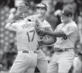  ?? Brian Cassella Chicago Tribune By Andy McCullough ?? KYLE FARMER, whose two-run double lifted the Dodgers in the opener of a doublehead­er, messes around with Cody Bellinger, middle, and Yasiel Puig.