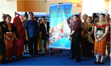  ??  ?? Abdul Mutalib (fourth right) unveils the ‘The Colours of Sarawak’ banner with Malaisamsu­l (fifth right) at the KIA yesterday.