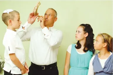  ?? (Mendy Hechtman/Flash90) ?? A MAN blows a shofar for his family, as is customary every morning during the month of Elul.