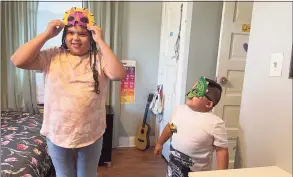  ?? Abigail Brone / Hearst Connecticu­t Media ?? Norwalk resident Zabdiel Saravia Valenzuela poses in a dinosaur mask next to his older sister, Andrea, after receiving a newly designed bedroom from Make-A-Wish.