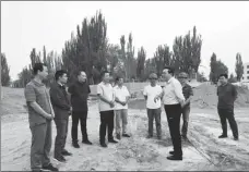  ?? PHOTOS COURTESY OF XINJIANG DAILY ?? Liu (fourth from left) discusses the project to bring drinking water to people in Jiashi county, Xinjiang Uygur autonomous region, with colleagues;