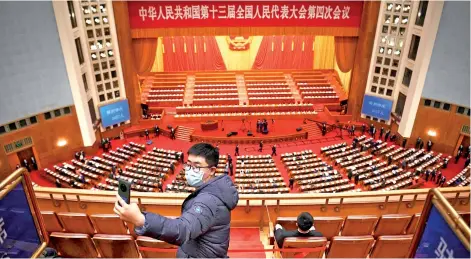  ?? Photo — AFP ?? A man takes a selfie before the start of the second plenary session of the National People’s Congress (NPC) at the Great Hall of the People in Beijing.