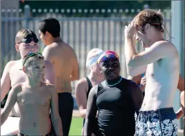  ??  ?? YUMA HEAT SWIMMERS Andrie Boyko (left), Austin Bender (back left) and Faith Braithwait­e (middle) converse with Sun sports editor Grady Garrett (right) about his lack of a swimming background before Garrett’s race against Mark Van Voorst on Monday at Valley Aquatic Center.