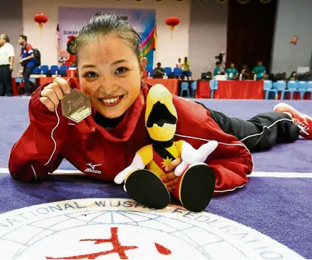  ??  ?? Sweet victory: A jubilant Phoon Eyin of negri Sembilan posing with her gold medal after winning the qiangshu event yesterday.