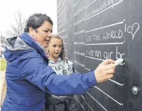  ?? FRAM DINSHAW/TRURO NEWS ?? Toni Thompson and her daughter Charley chalk up a few life goals on the Before-i-die’ board set up outside the Truro Farmers’ Market on May 4.