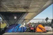  ?? Kent Nishimura Los Angeles Times ?? LETTING THE homeless stay in their tents, like these under the 110, lowers their contact with others.