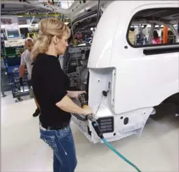  ?? , CANADIAN PRESS FILE PHOTO ?? A worker on the production line at Chrysler’s assembly plant in Windsor works on a minivan.