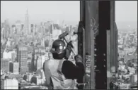  ??  ?? SKYSCRAPER: In this Dec. 16, 2010 photo, an ironworker connects a steel plate to a column at One World Trade Center in New York. The Empire State Building is visible in the rear upper left. One World Trade Center, the giant monolith being built to...