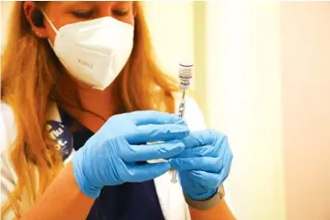  ?? JIM WILSON/THE NEW YORK TIMES ?? A health care worker prepares a COVID-19 booster in San Rafael, Calif., on Sept. 29. The Food and Drug Administra­tion and Centers for Disease Control and Prevention have endorsed booster shots, but scientific advisers have never been certain that so many Americans need them.