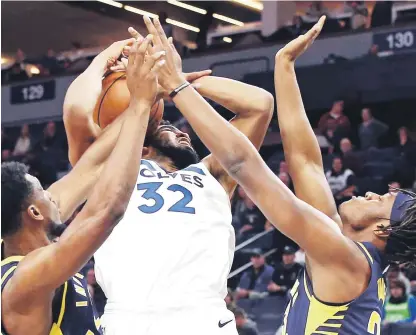  ?? AP ?? Karl Towns se disputa el balón con dos jugadores de los Pacers durante el choque de anoche.