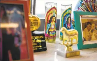  ??  ?? DEVOTIONAL CANDLES and other “Jane the Virgin” memorabili­a in Urman’s office in Encino.