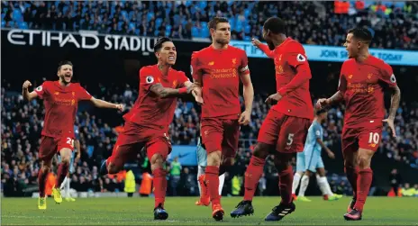  ?? Picture: JASON CAIRNDUFF, REUTERS ?? THE RED TIDE WASHES IN: Liverpool’s James Milner celebrates with teammates after scoring against Manchester City yesterday.