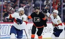  ?? MATT SLOCUM — THE ASSOCIATED PRESS ?? Florida Panthers’ Jonathan Huberdeau, left, and Sam Bennett, right, celebrate past Philadelph­ia Flyers’ Keith Yandle after Huberdeau’ s goal during the third period of an NHL hockey game, Saturday.