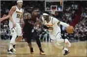  ?? REBECCA BLACKWELL — THE ASSOCIATED PRESS ?? Nuggets guard Reggie Jackson, right, pushes past Heat guard Terry Rozier, middle, as Nuggets forward Aaron Gordon watches during the first half Wednesday in Miami.
