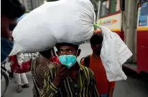 ?? AP ?? A migrant worker arrives at a New Delhi bus station to leave for his village as Covid19 cases spiral out of control in India, with daily infections approachin­g 300,000.