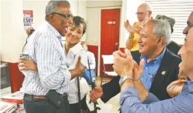  ?? STAFF PHOTO BY ROBIN RUDD ?? Erskine Oglesby is embraced by his wife, Sheryl, as supporters celebrate his victory over incumbent Chris Anderson in the runoff election for District 7 at the campaign’s headquarte­rs in Alton Park.