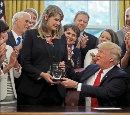  ??  ?? No standing on ceremony: President Trump presents Sydney Chaffee of Dorchester, Massachuse­tts, with the national teacher of