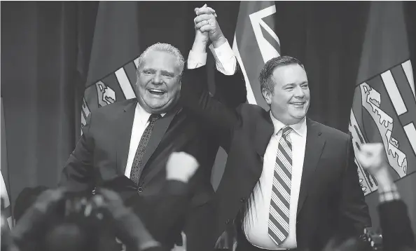  ?? JEFF MCINTOSH / THE CANADIAN PRESS FILES ?? Ontario Premier Doug Ford, left, and Alberta United Conservati­ve Party Leader Jason Kenney cheer with supporters at an anti-carbon tax rally in Calgary in October.