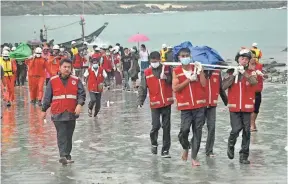  ??  ?? ZAW ZAW PHYO, EUROPEAN PRESSPHOTO AGENCY Rescue workers carry the victim of a crashed military transport plane Thursday on the shore by SanLann village near Laung Lone township of southern Taninthary­i region, Myanmar. At least 31 bodies have been...