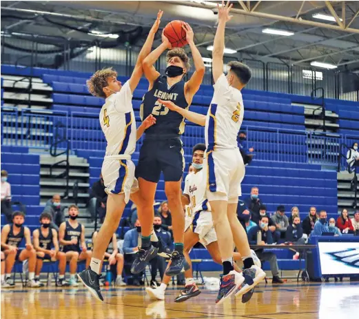  ?? ALLEN CUNNINGHAM/SUN TIMES ?? Lemont’s Nojus Indrusaiti­s (23) shoots over Sandburg’s Martin Petraitis (left) and Ryan McPolin on Tuesday in Orland Park.