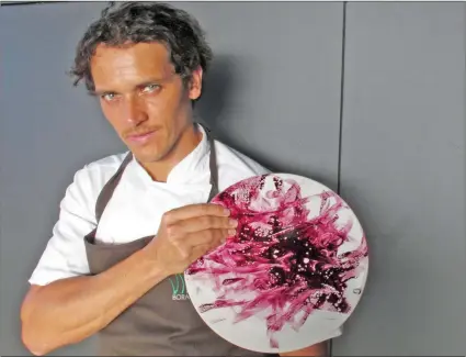  ?? LUIS ANDRES HENAO/AP ?? Chef Rodolfo Guzman holds up a plate smeared with maqui berries, in Santiago.