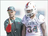  ?? AL DIAZ / MIAMI HERALD ?? New Miami defensive coordinato­r Manny Diaz, who’s responsibl­e for improving the run defense after it ranked 115th nationally last season, offers advice to linebacker Charles Perry during a practice in early August.