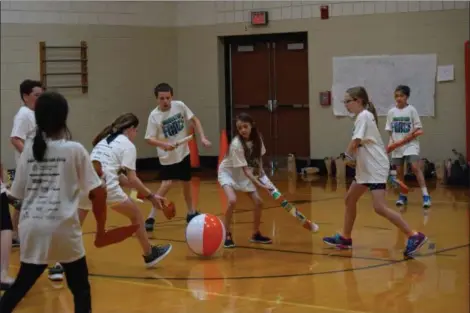  ?? MARIAN DENNIS — MEDIANEWS GROUP ?? Campers at Camp Invention play a game they created themselves using hockey sticks made out of recyclable­s.