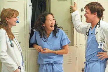  ?? ABC ?? Ellen Pompeo (left) and Sandra Oh confer with T.R. Knight on “Grey’s Anatomy.” Knight was on the show from 2005 to 2009, when his character was hit by a bus.