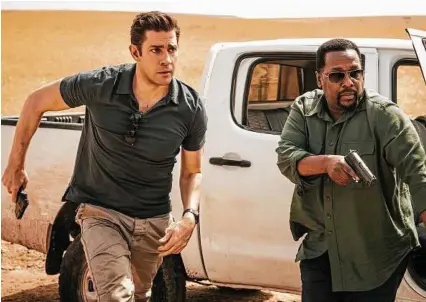  ?? Jan Thijs / Amazon via AP ?? John Krasinski, left, and Wendell Pierce appear in a scene from the new Amazon series “Tom Clancy’s Jack Ryan,” which debuts Friday.