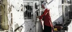  ??  ?? SILVAN, Turkey: A picture taken on Nov 14, 2015 shows a Kurdish woman trying to open the door of her home after clashes between Turkish forces and Kurdish militants. —AFP