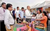  ??  ?? SLPA Chairman General Daya Ratnayake speaking with souvenir and gift item stall owners atport of Colombo