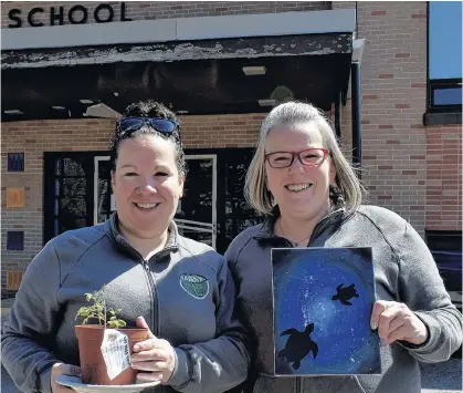  ?? MICHAEL ROBAR/THE GUARDIAN ?? Tara MacKean, left, and her sister, Cheryl Newcombe hold a tomato plant and a finished painting outside Englewood School, one of the two schools they use for the school age program they run at Merry Pop-Ins Childcare Centre in Tryon.