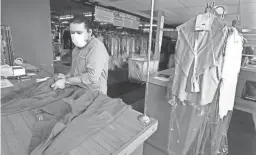  ?? RICK WOOD/USA TODAY NETWORK ?? Owner Oscar Marin completes an order at Prestige Dry Cleaners in Milwaukee. The shop closed in March and reopened in May.